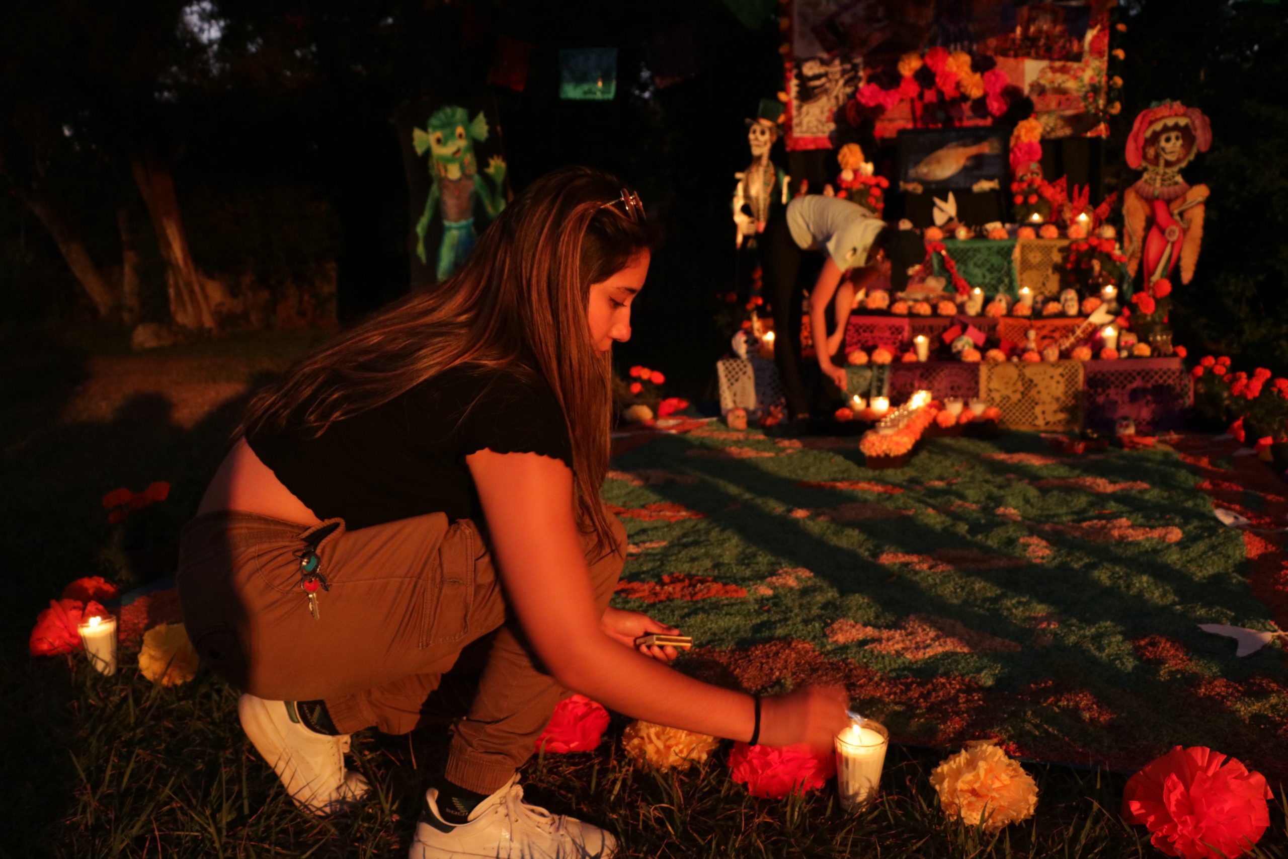 Day of the Dead, or Día de los Muertos, celebrations in Mexico. A student decorates a golden skiffia themed altar