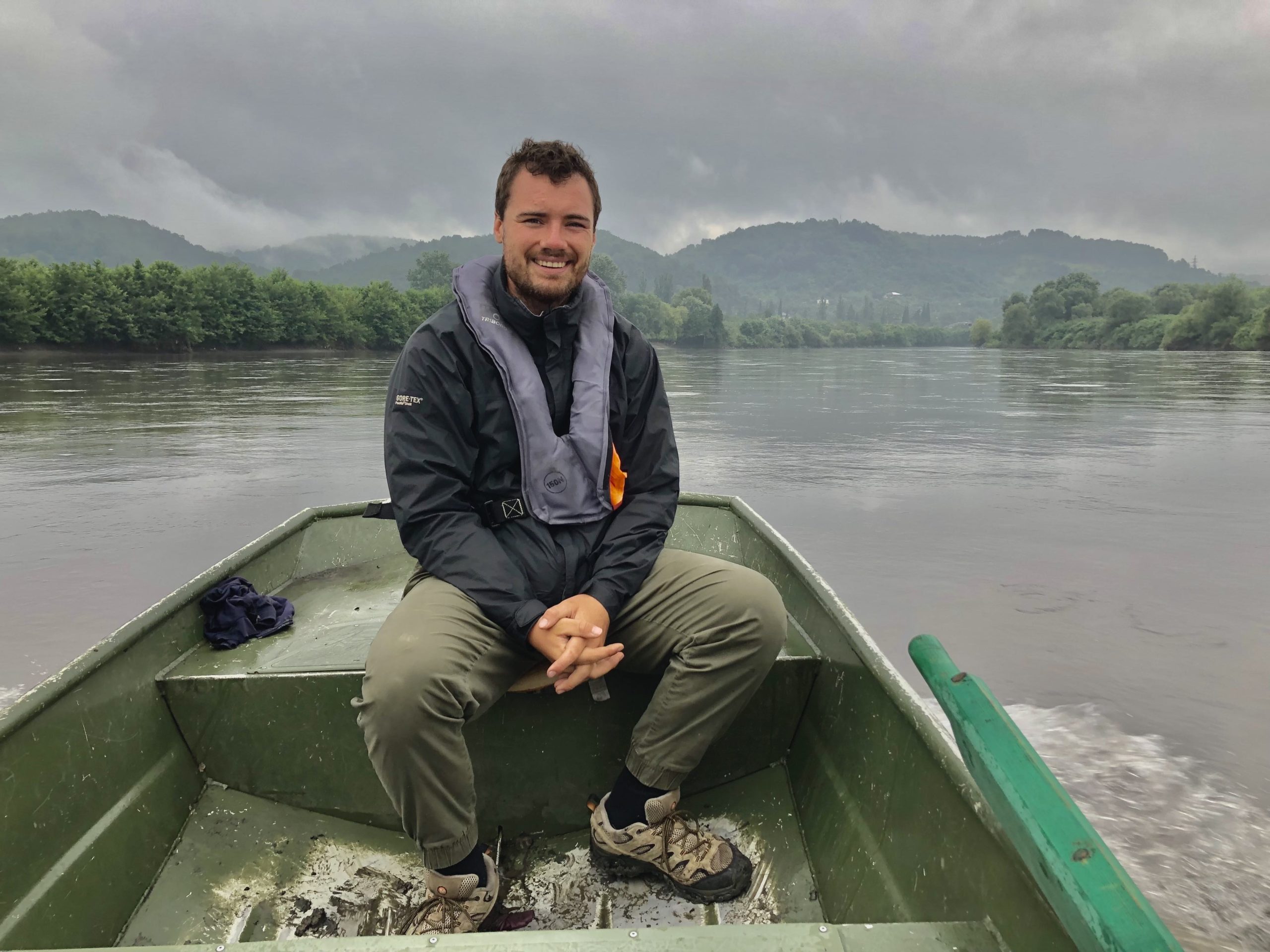 A photograph of Matt Spencer in a small boat on his cycling for sturgeon journey.