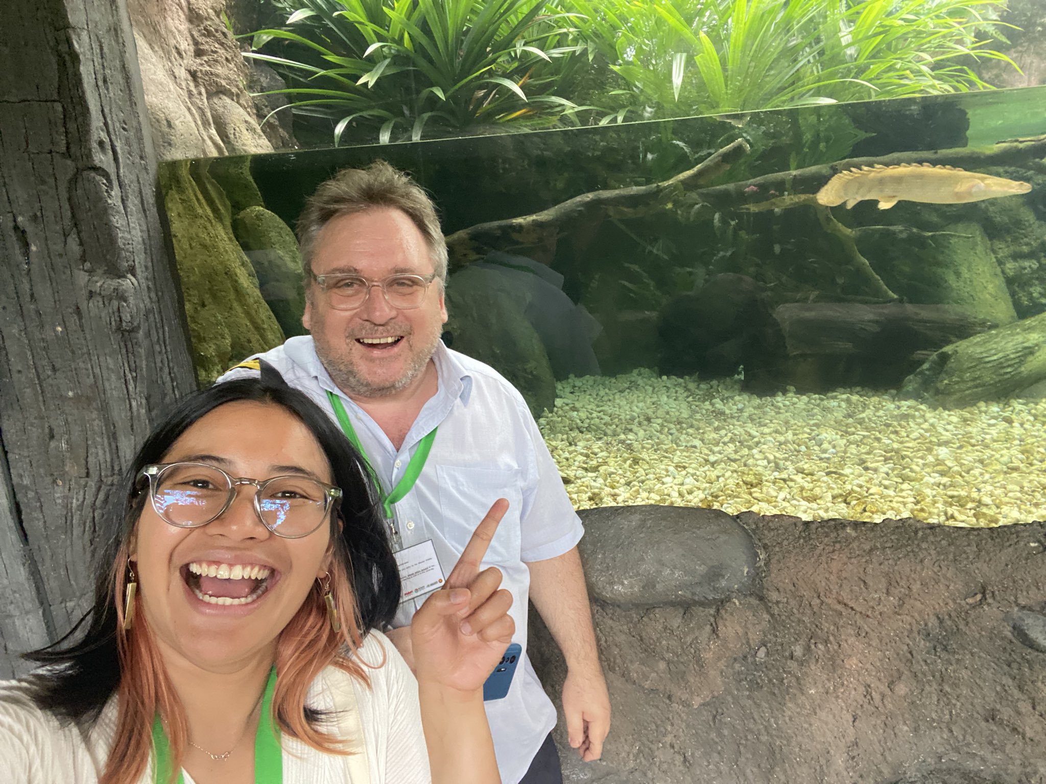A photograph of a man and a woman in front of an aquarium.