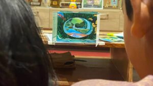 School children looking through the tunnel book, depicting a river ecosystem © Shyamkumar
